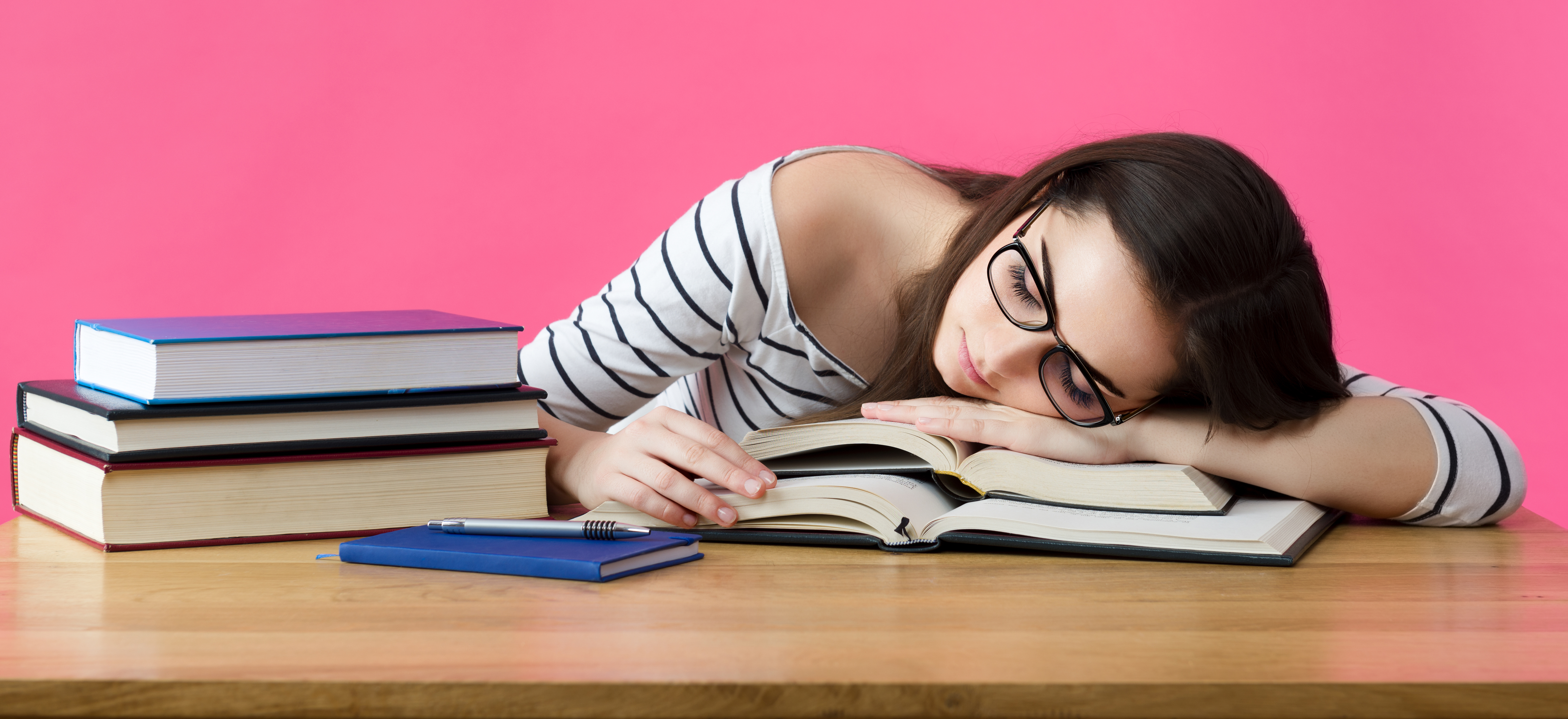 Etudiante dormant sur des livres